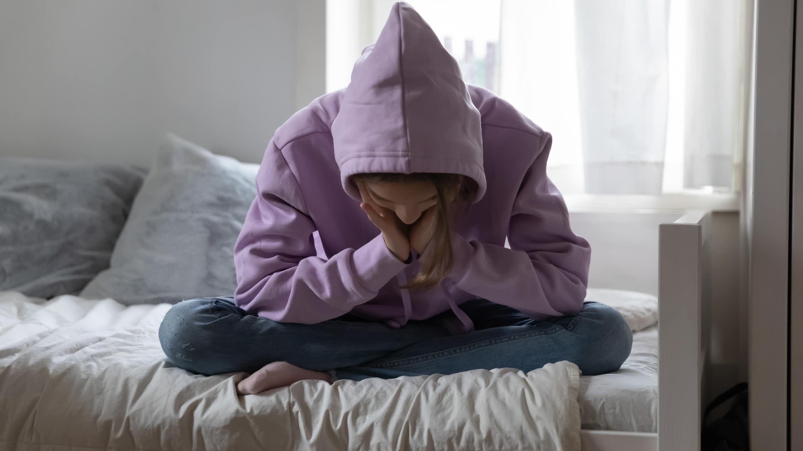 Una chica con sudadera exhibe signos de abatimiento