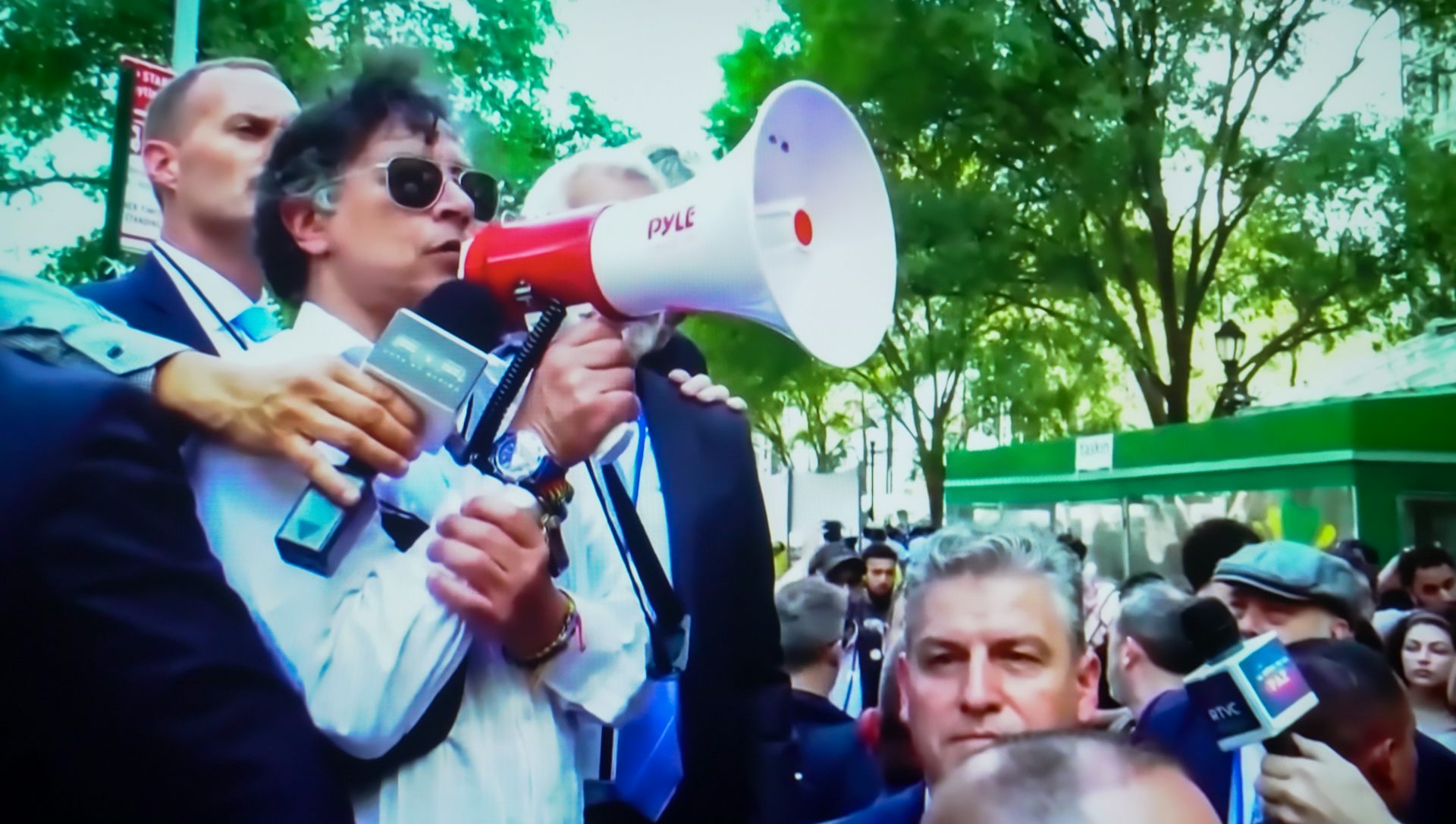 Un hombre con un megáfono rodeado de personas