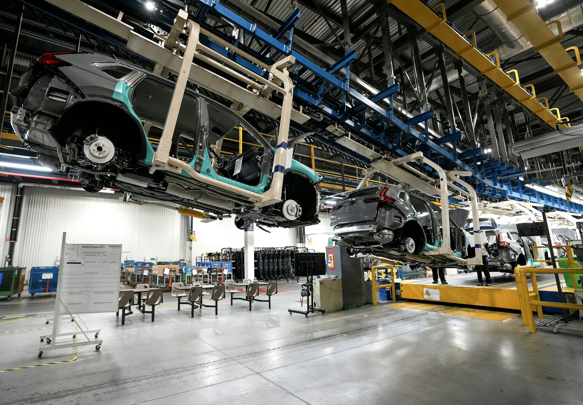 Un automóvil sin terminar que se mueve sobre una vía elevada en una planta de ensamblaje