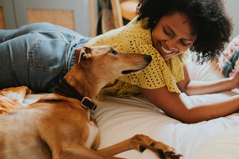 A woman smiles lovingly at her dog.