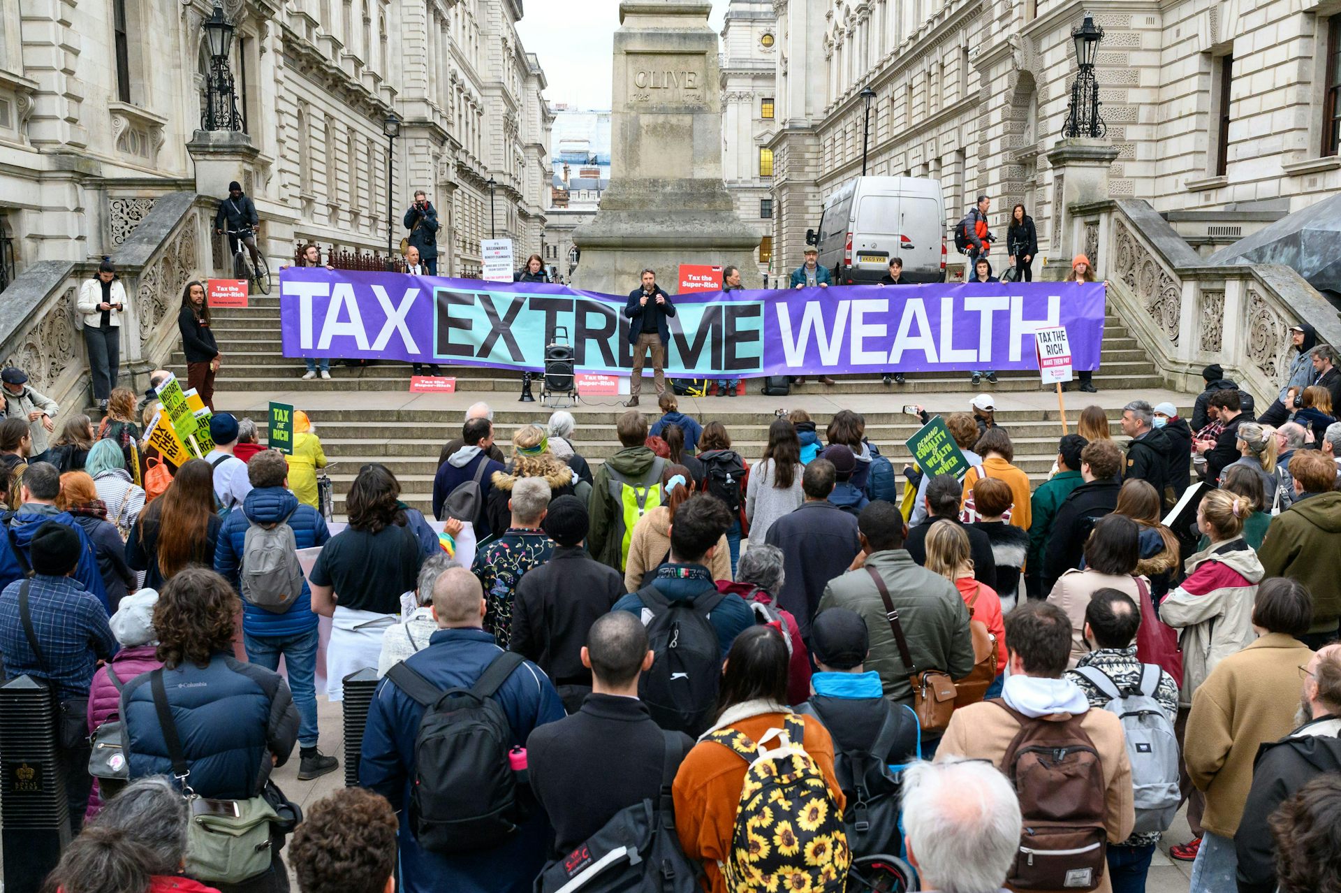 Protesters outside the Treasury in London with a banner calling to 'tax extreme wealth'.