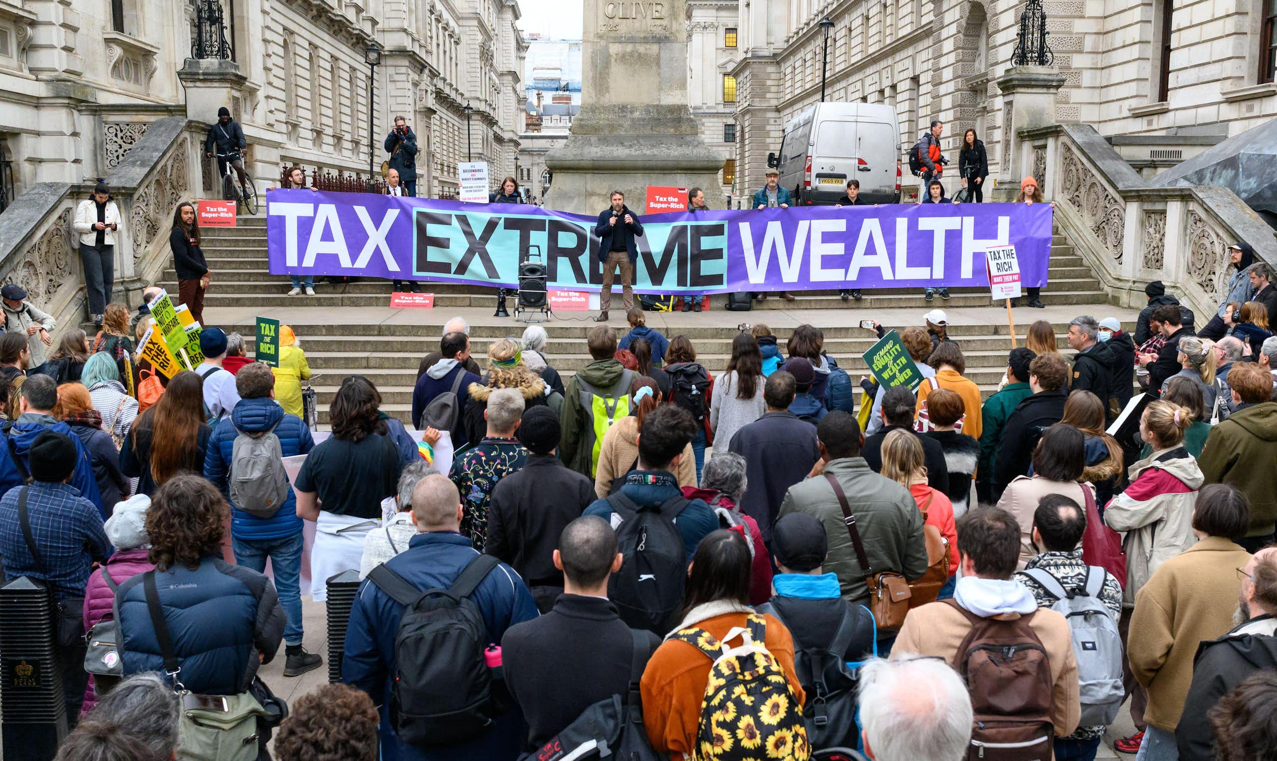 Protesters outside the Treasury in London with a banner calling to 'tax extreme wealth'.