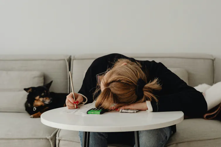 A woman sitting with her head down on a table