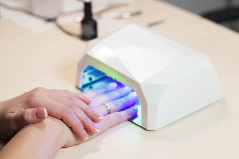 Gel nails curing under a UV lamp.