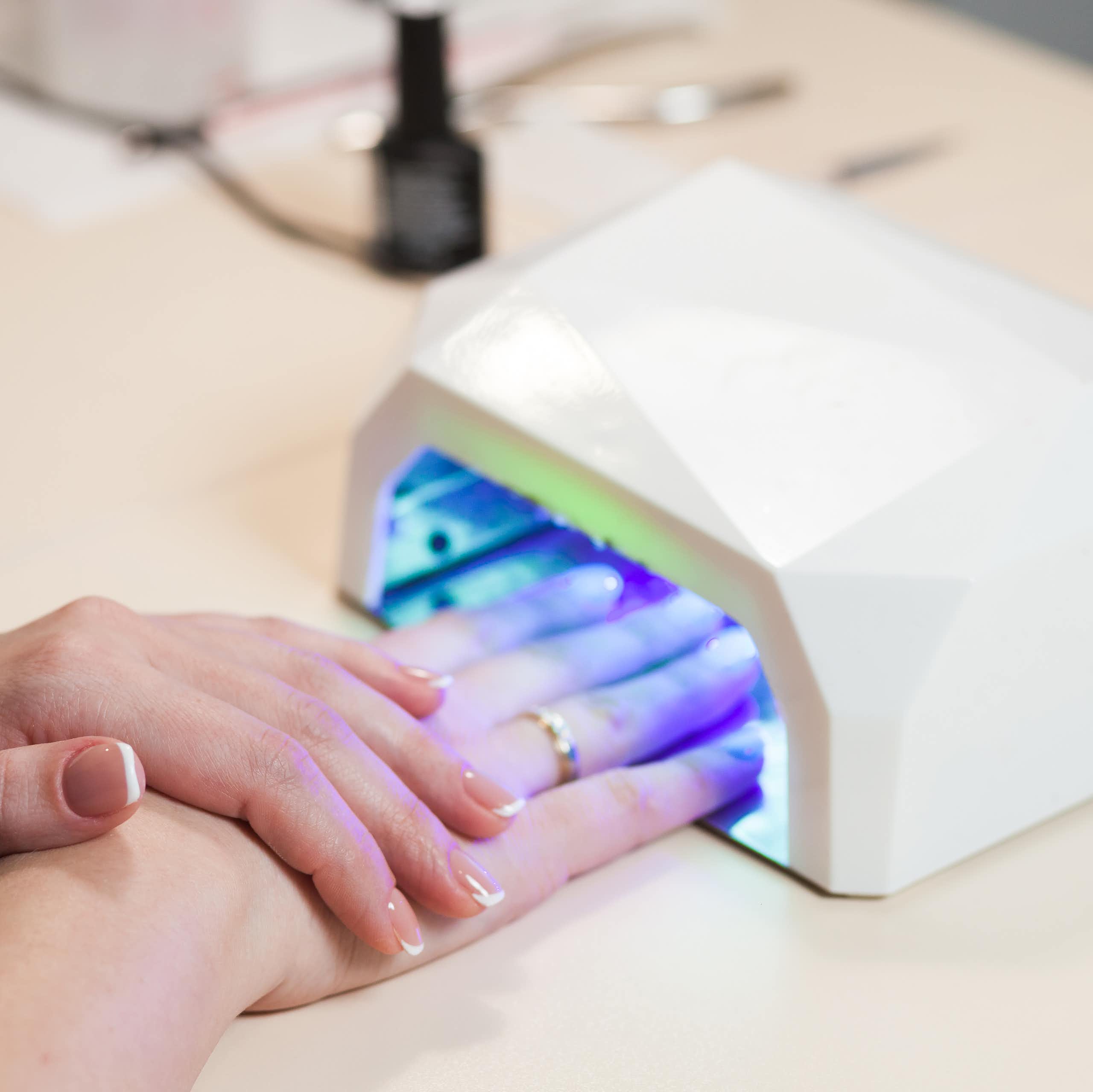 Gel nails curing under a UV lamp.