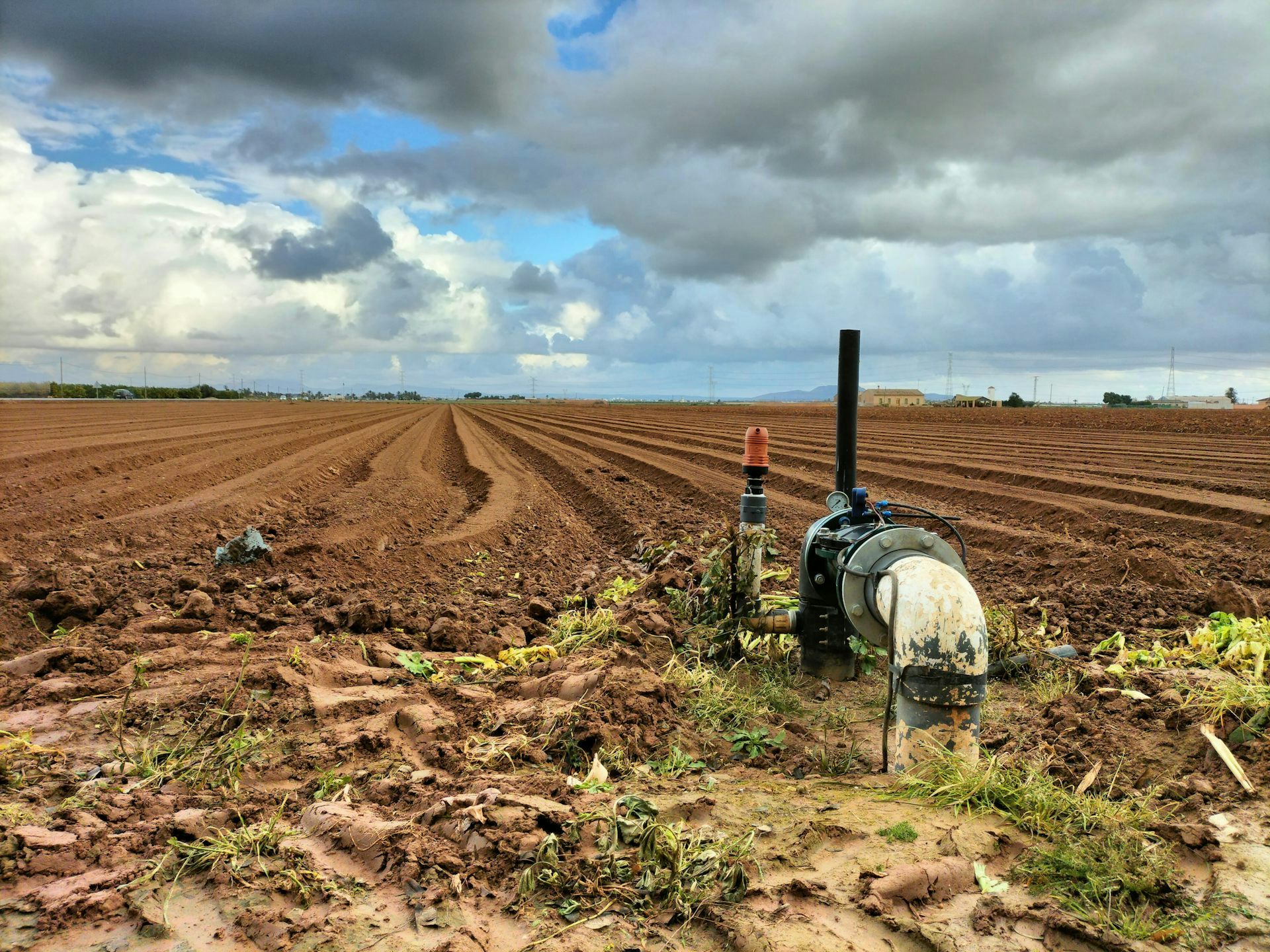 Paisaje que muestra un campo agrícola sin plantas todavía y una tubería para el regadío