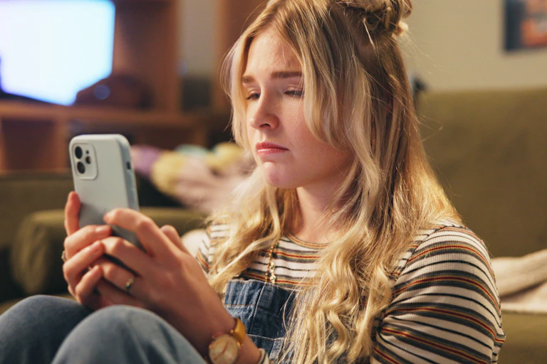 Young woman looking sadly at phone