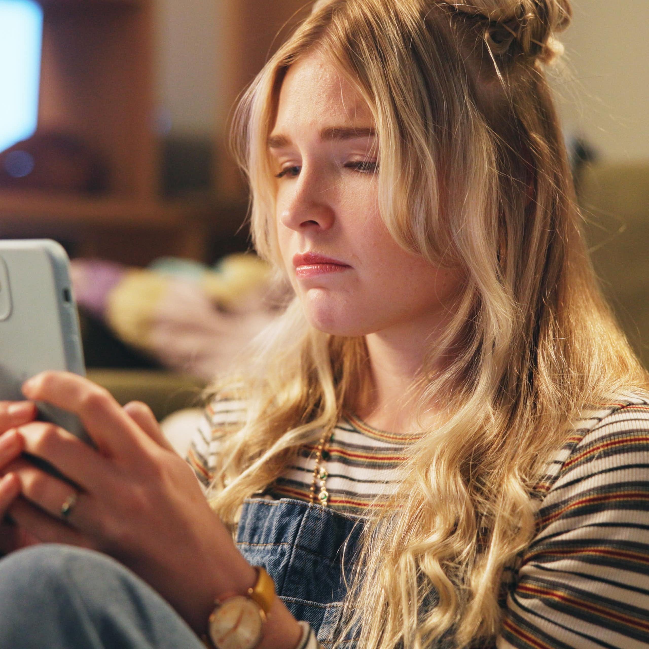 Young woman looking sadly at phone