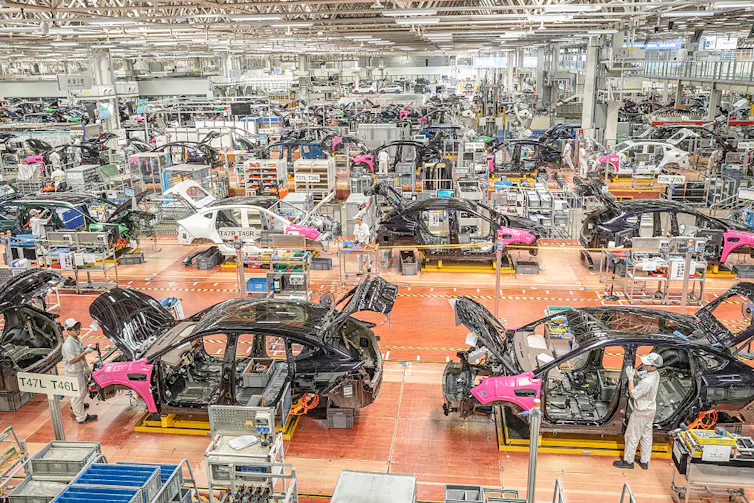 Car parts are fitted in a big warehouse.