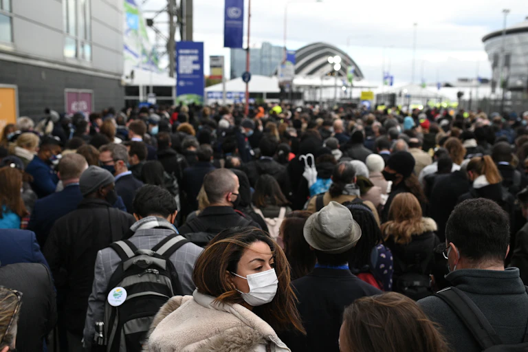 A crowd of people is seen in front of a building or event space in the distance.