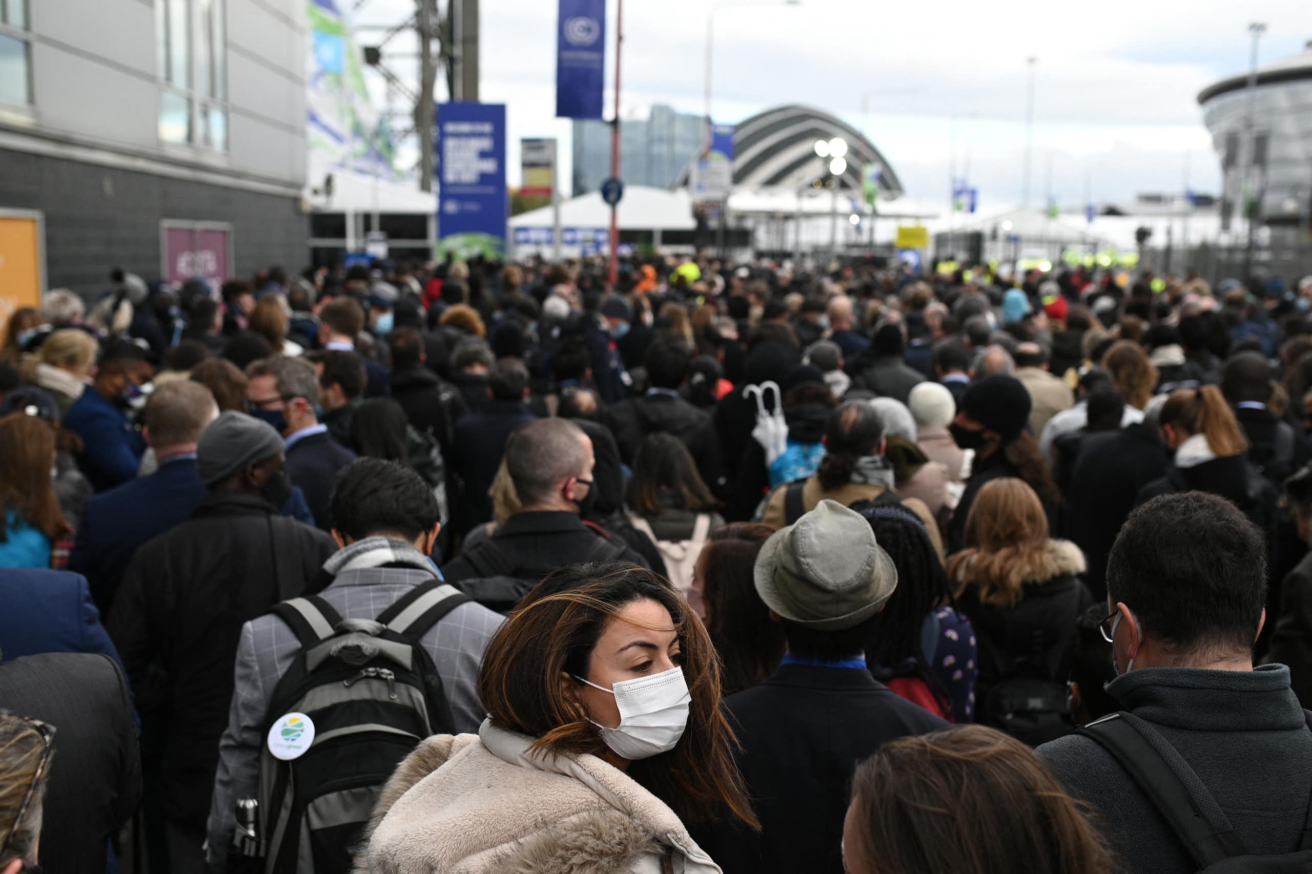 A crowd of people is seen in front of a building or event space in the distance.