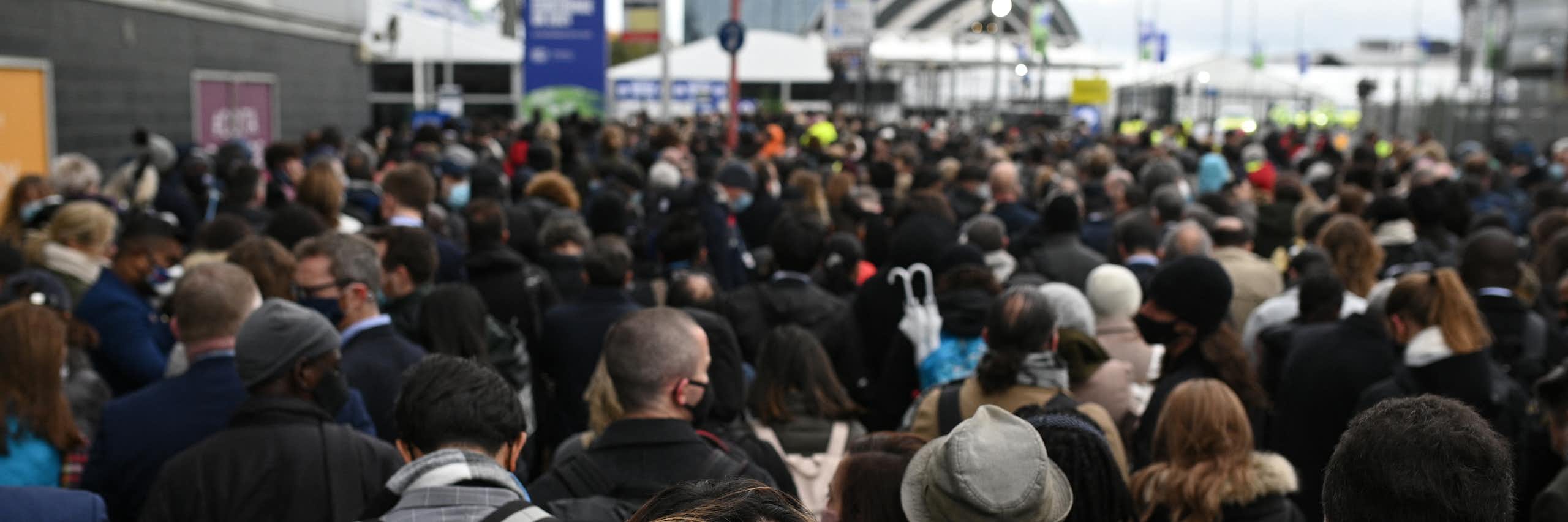 A crowd of people is seen in front of a building or event space in the distance.
