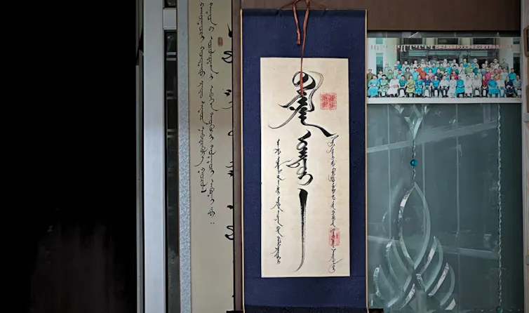 A sign hung on a door written in the Traditional Mongolian script.