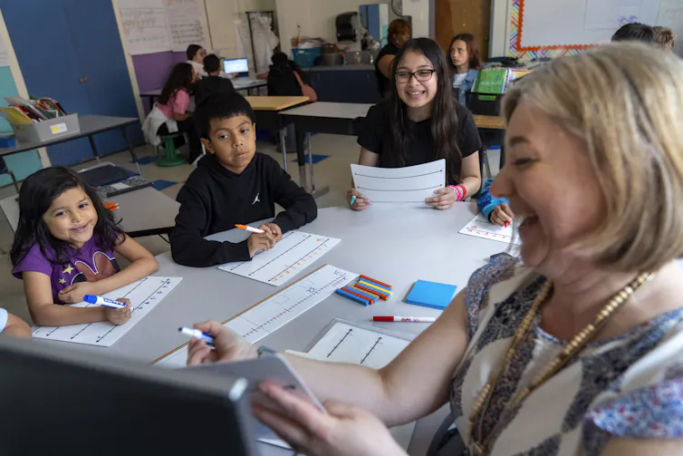 A teacher shows students a math lesson.