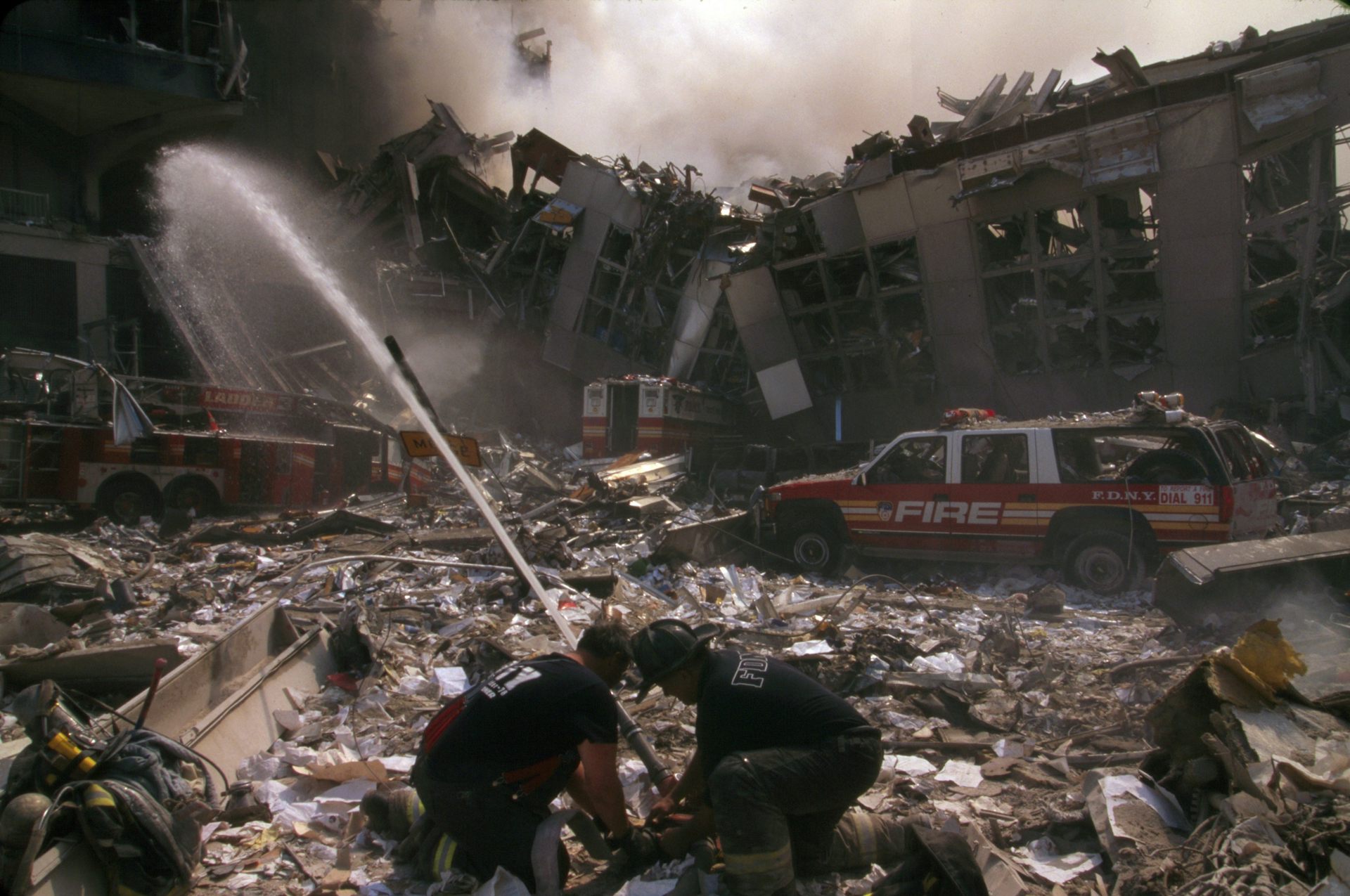 Firefighters train hoses over the rubble at the former site of the World Trade Center towers in New York City.