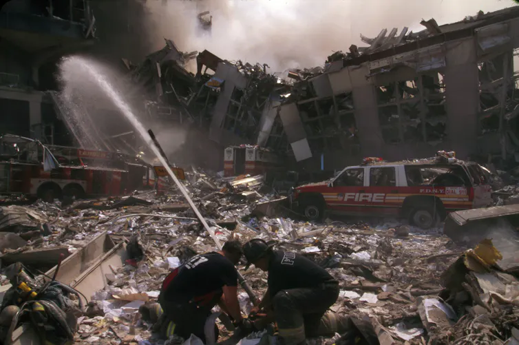 Firefighters train hoses over the rubble at the former site of the World Trade Center towers in New York City.