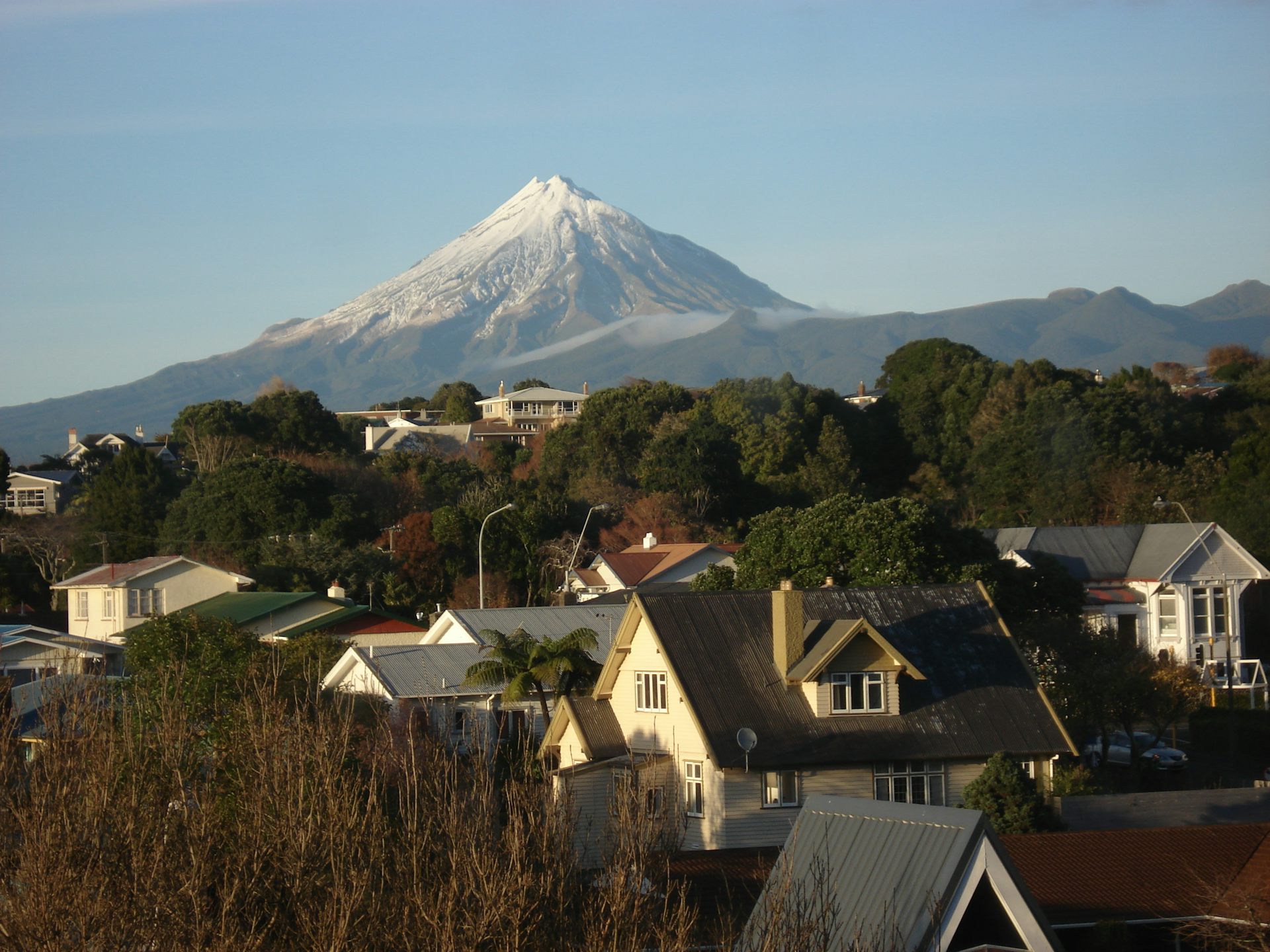 A snow-capped mountain behind residential houses.