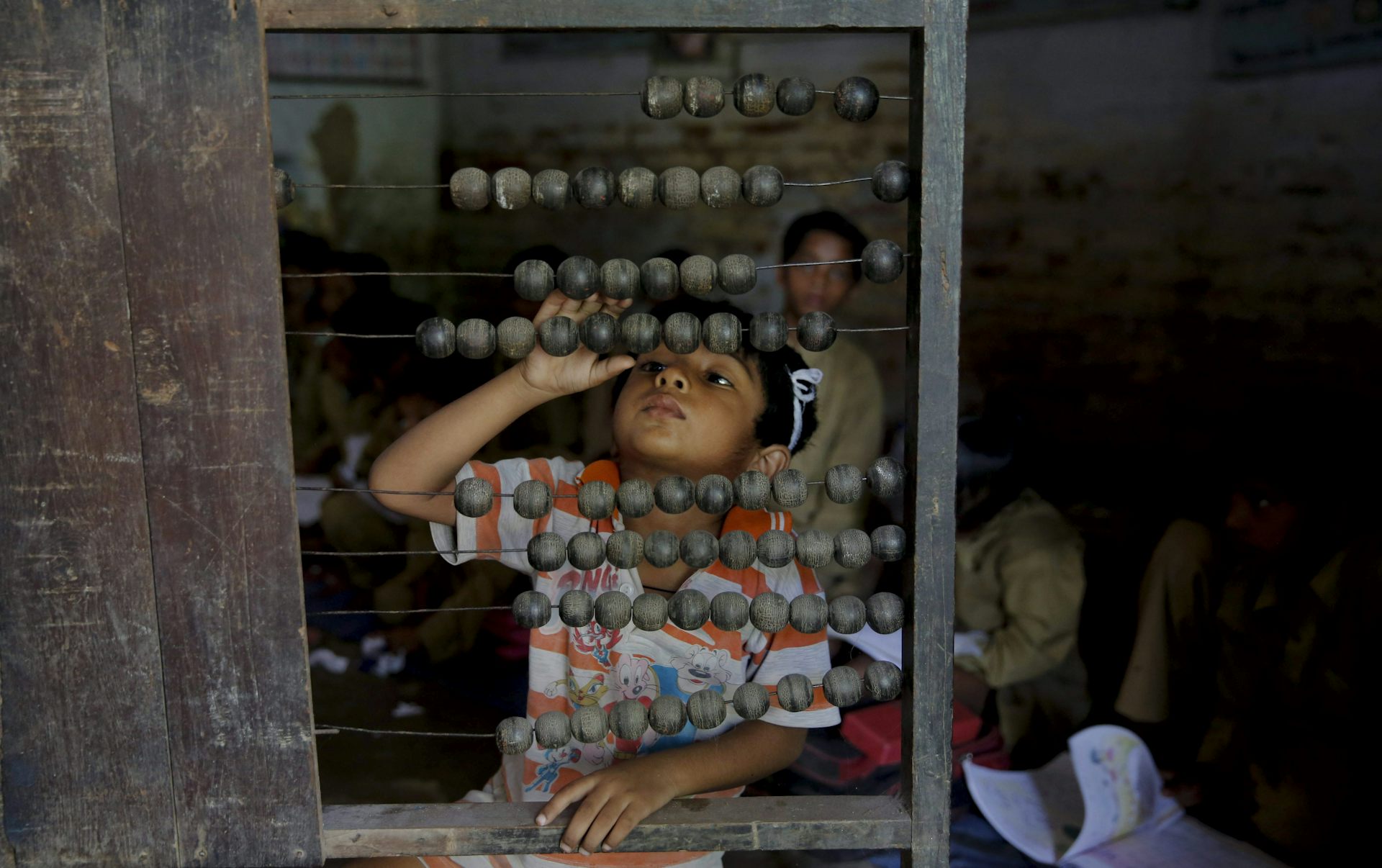 A young boy uses an abacus to count