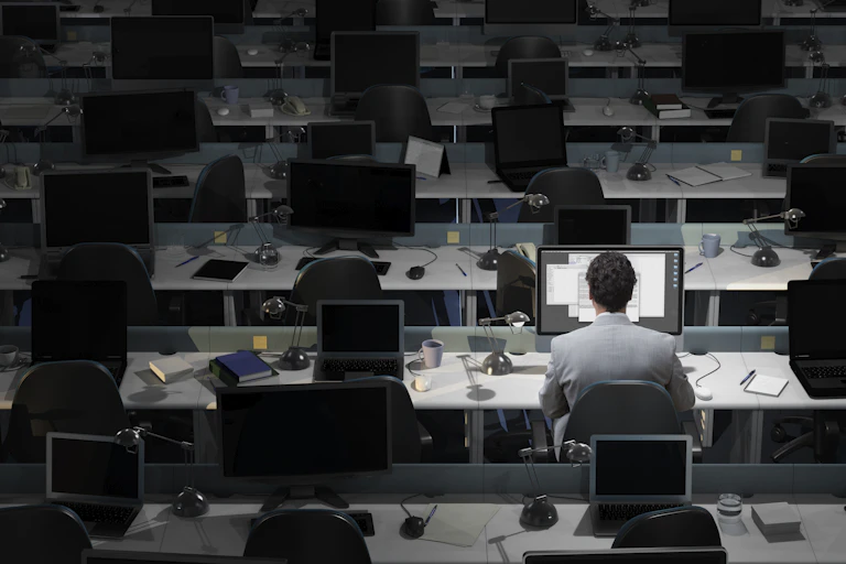 A man works in an otherwise empty office.