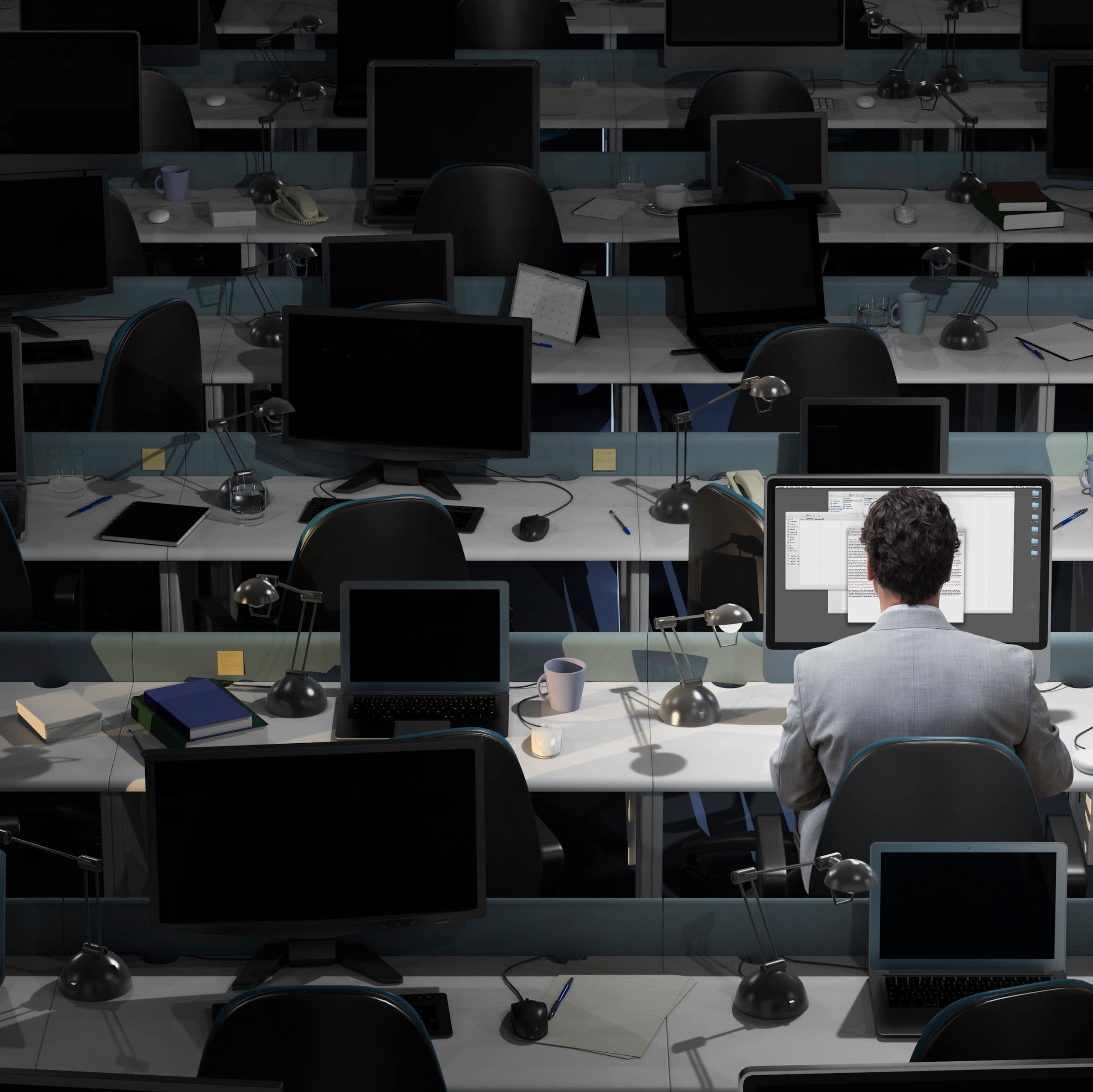 A man works in an otherwise empty office.