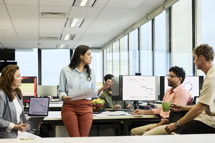 Businesswoman interacts with her with teammates in meeting at their office.