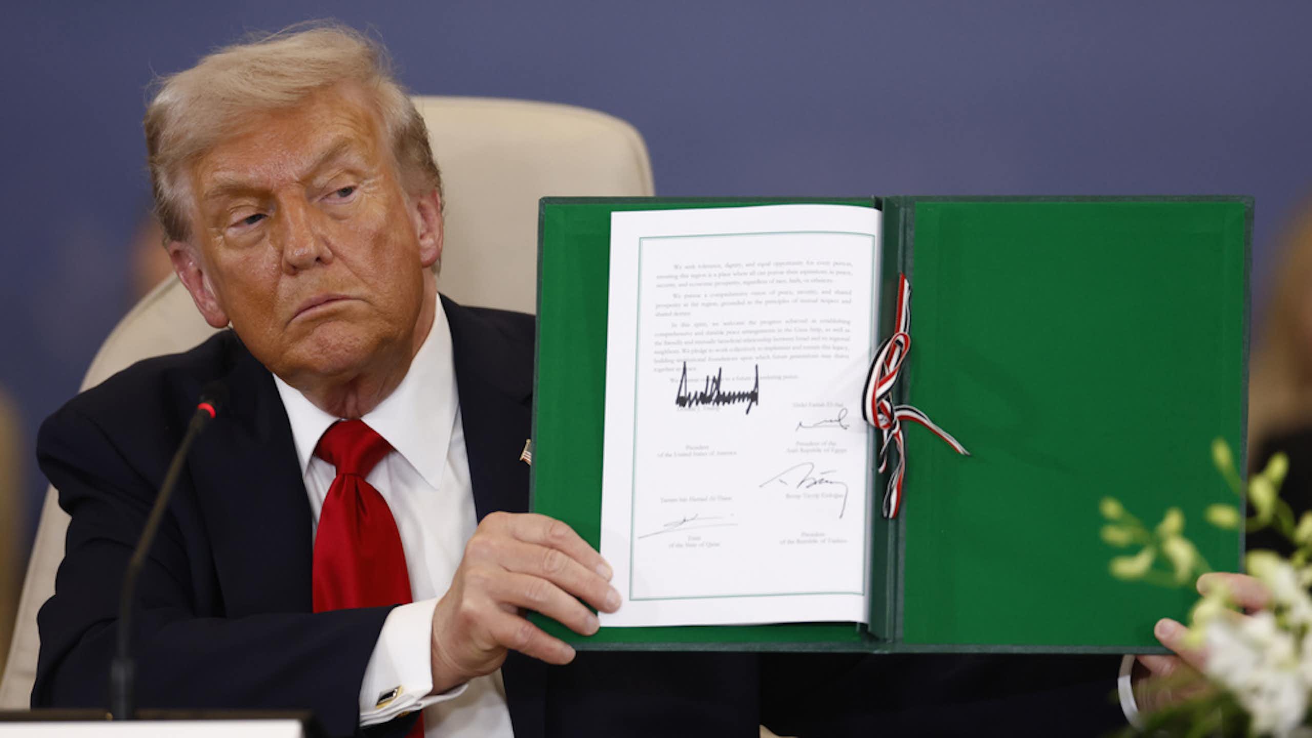 O presidente Donald Trump segura um papel com sua assinatura