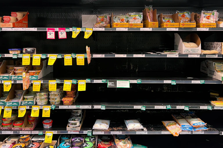 A row of half-empty supermarket shelves.