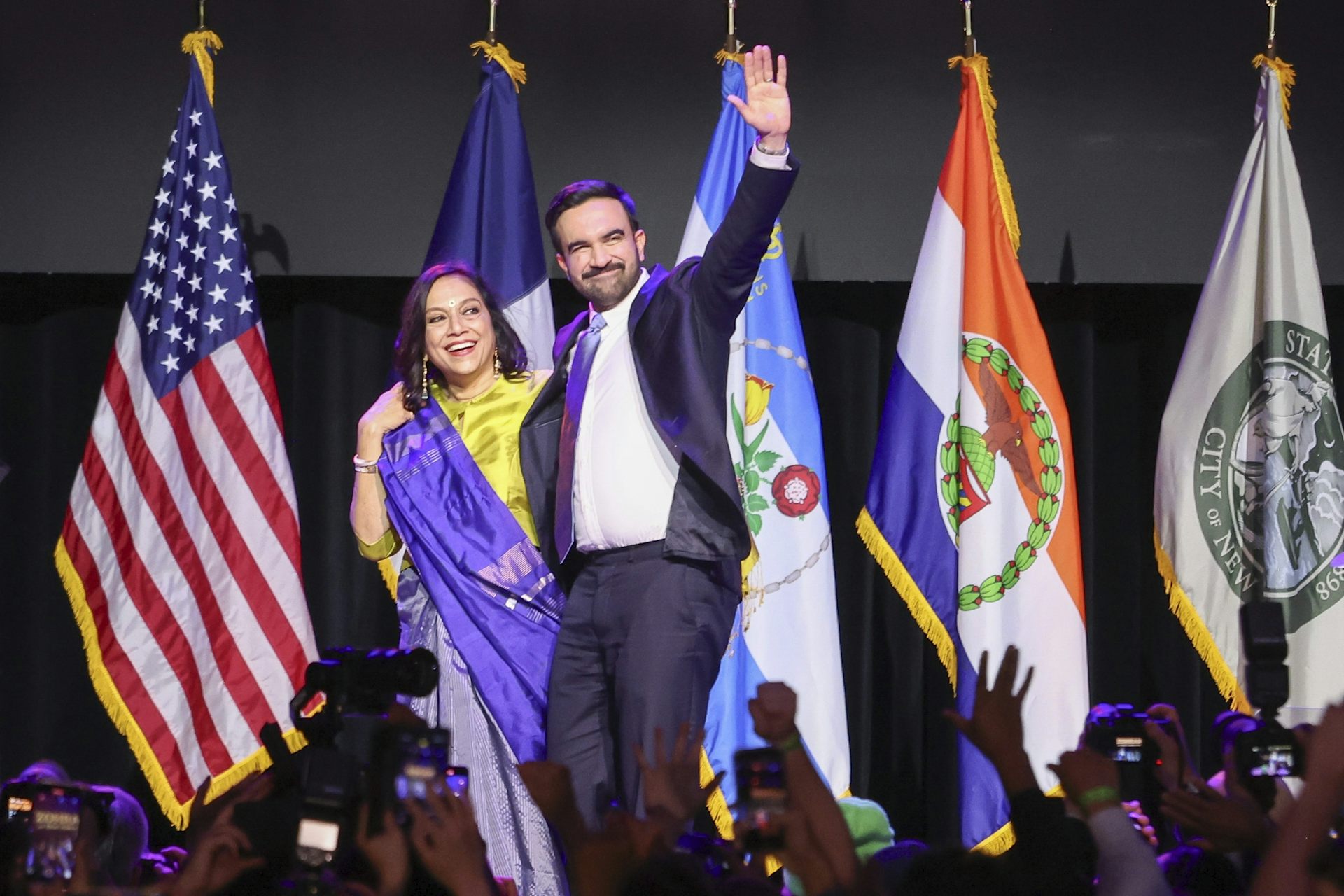The new mayor of New York City, Zohran Mamdani, waves to a crowd alongside his mother.