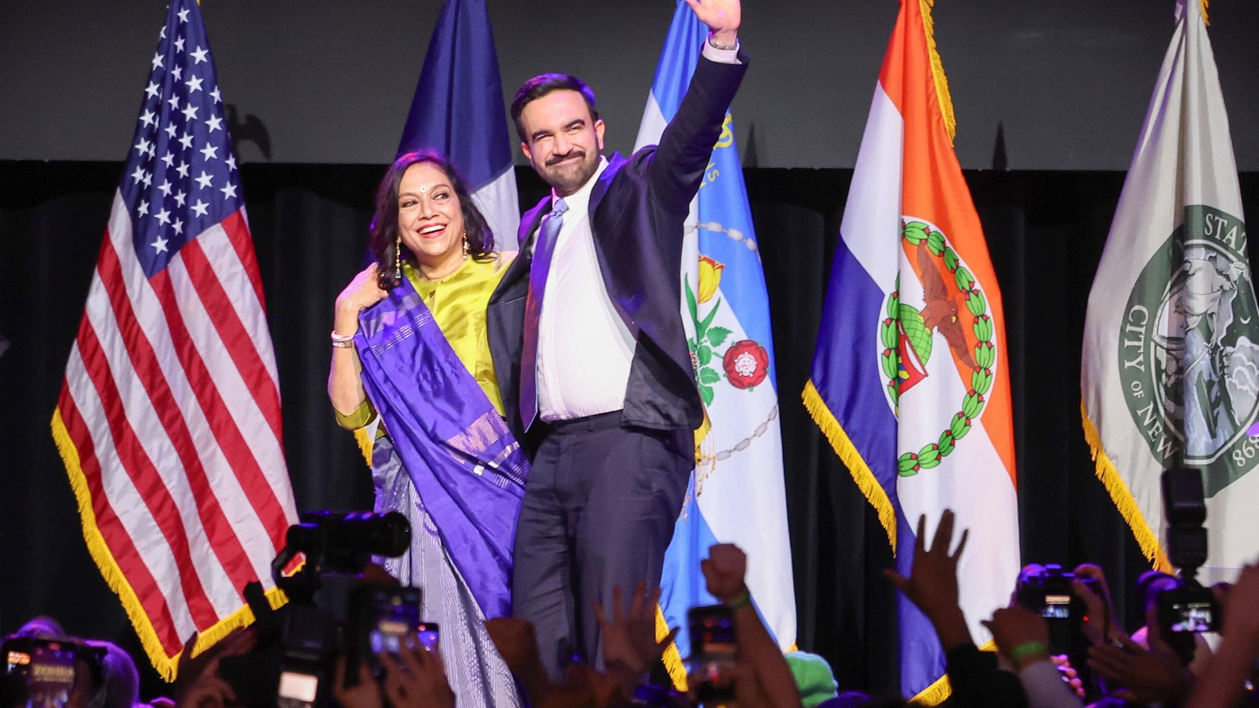 The new mayor of New York City, Zohran Mamdani, waves to a crowd alongside his mother.