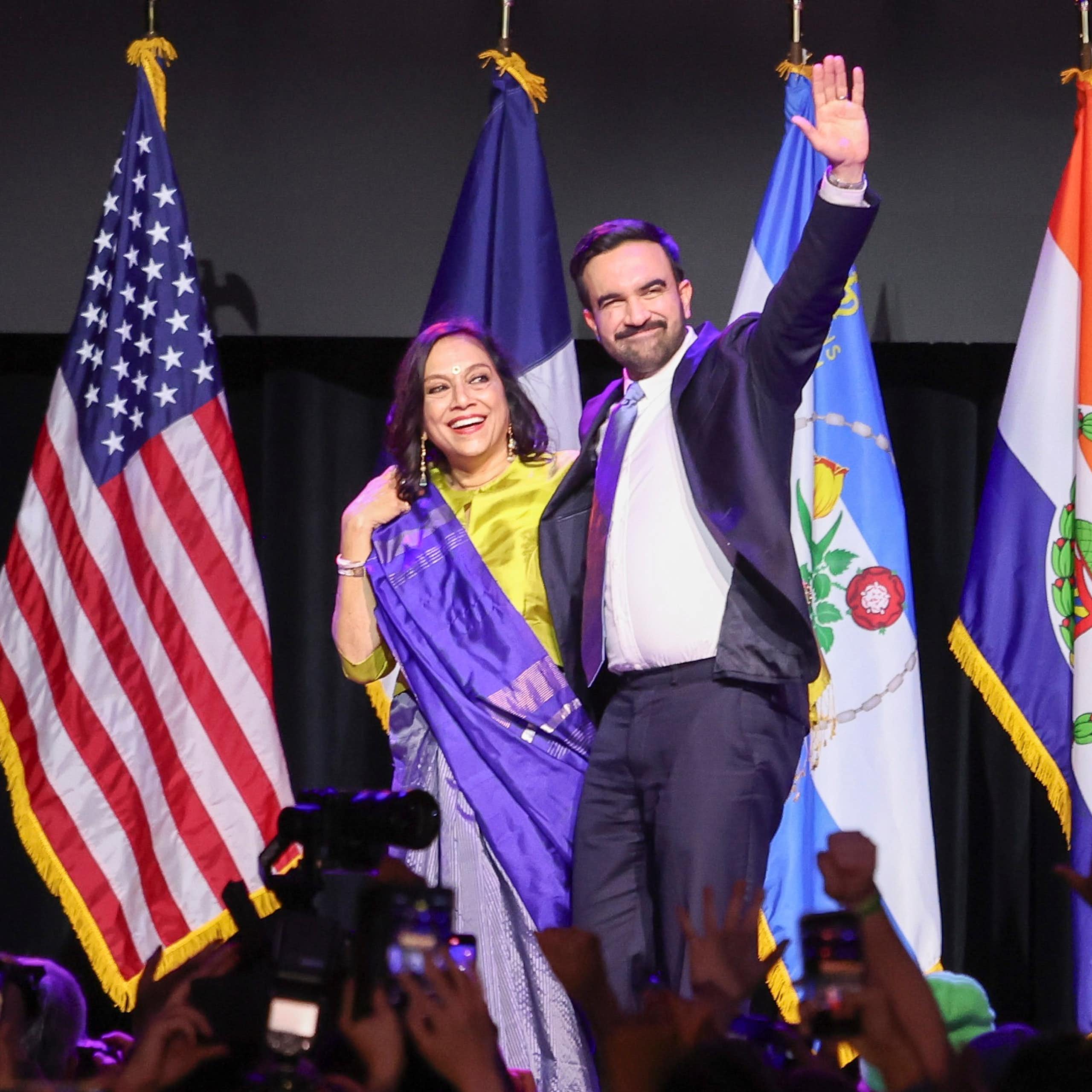The new mayor of New York City, Zohran Mamdani, waves to a crowd alongside his mother.