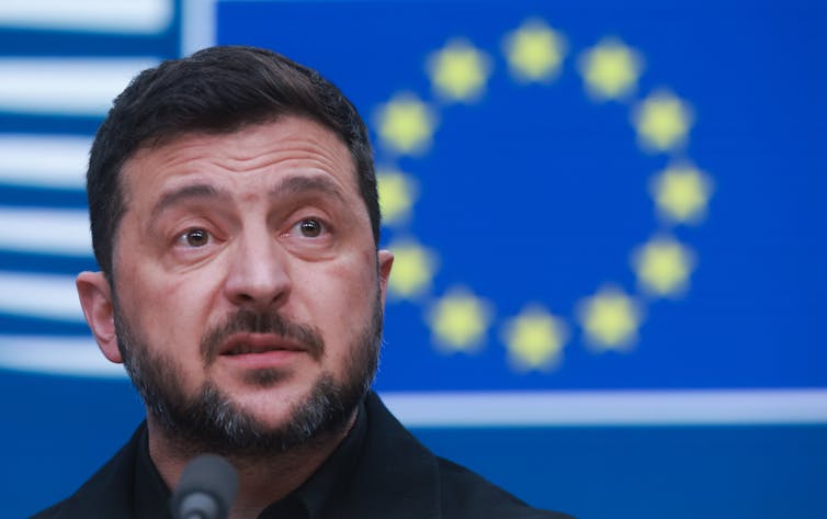 Loss of development on becoming a member of EU caps any other unhealthy month for Ukraine 1 Ukrainian president Volodymyr Zelensky next to the EU flag.