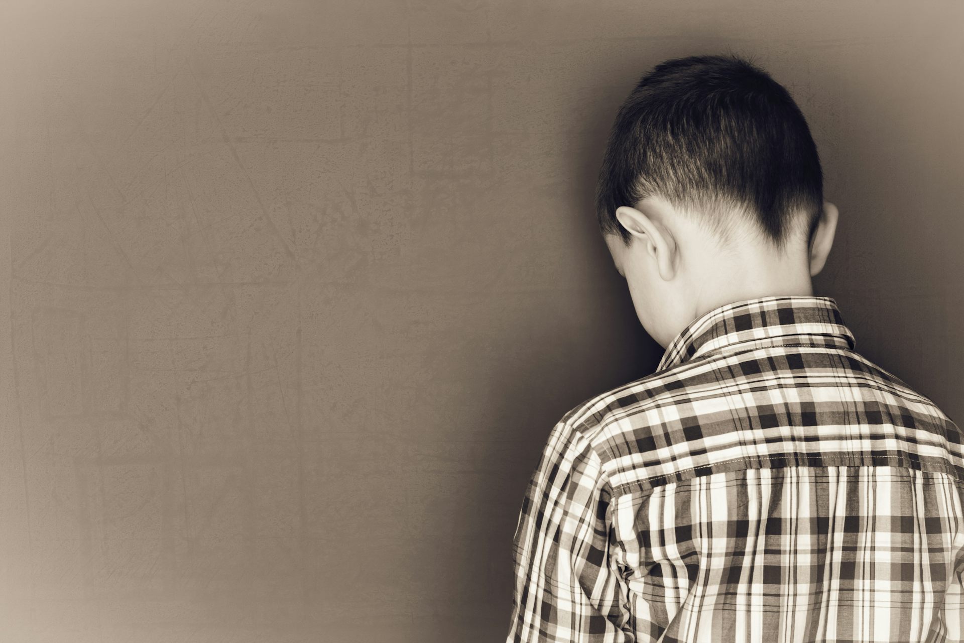 Un niño apoya la cabeza contra una pizarra