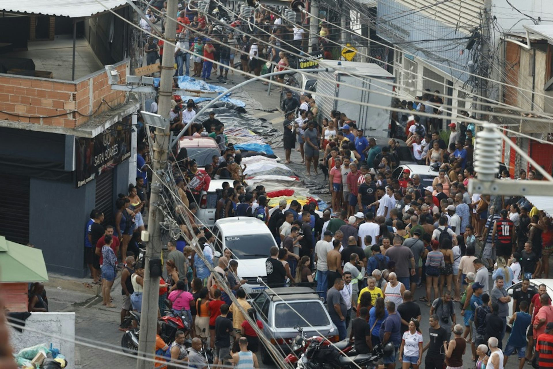 People crowd around a line of bodies in Rio de Janiero