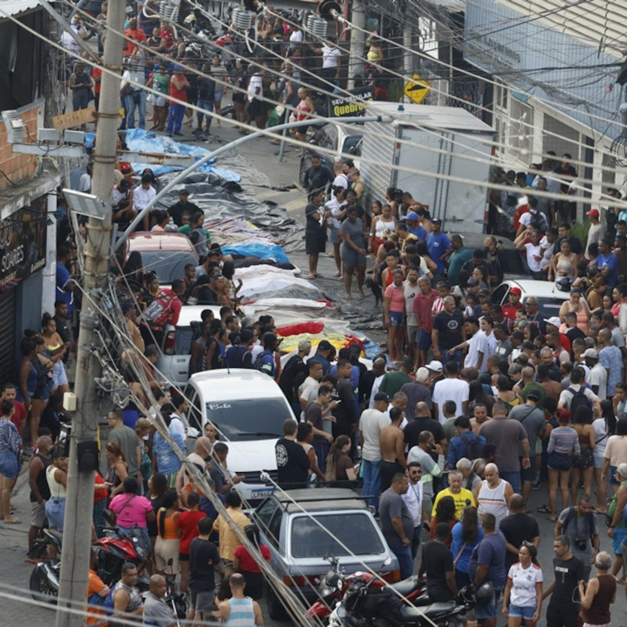 People crowd around a line of bodies in Rio de Janiero