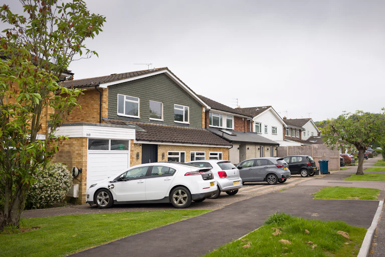 A row of houses with cars outside.