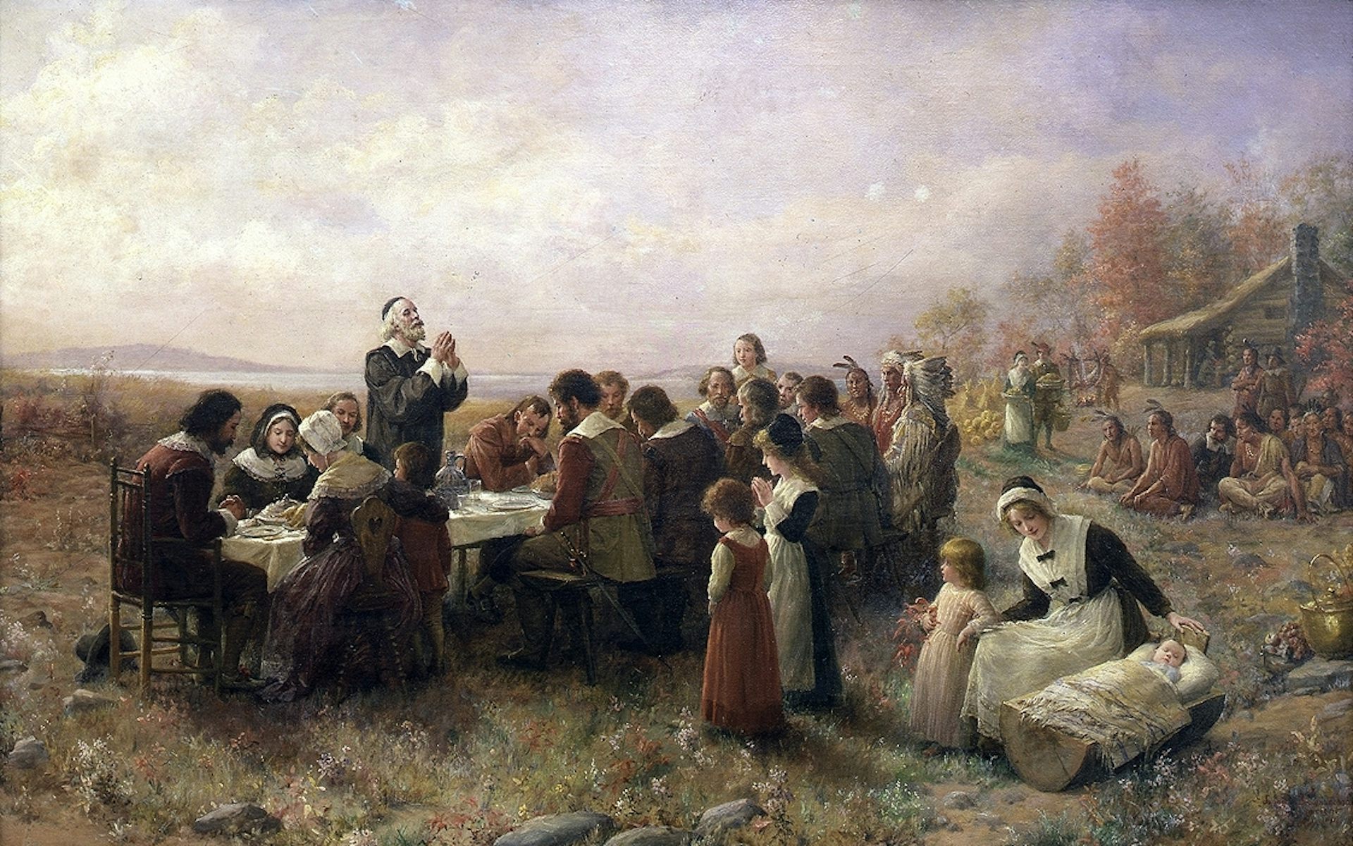 A painting in muted colors of a small group of people in plain clothing seated around a table outside, with a log cabin in the background.