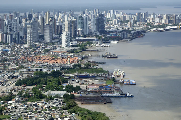 brazilian city and river seen from the air, skyscrapers and brown river.