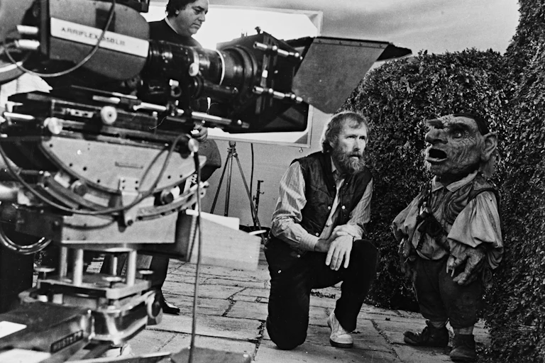 Jim Henson on set with a small puppet