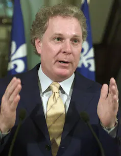 A man in suit and tie gestures with his hands.