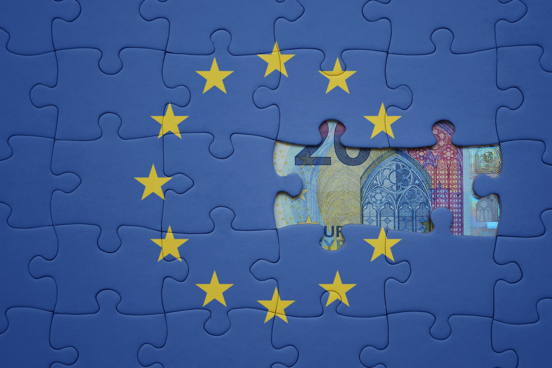 Un puzle de la bandera de la UE al que le falta una pieza y en cuyo hueco se puede ver un billete de 20 euros.