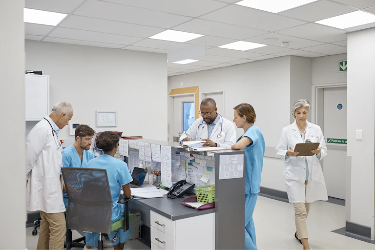 Busy-looking doctors huddling around the administrative desk.