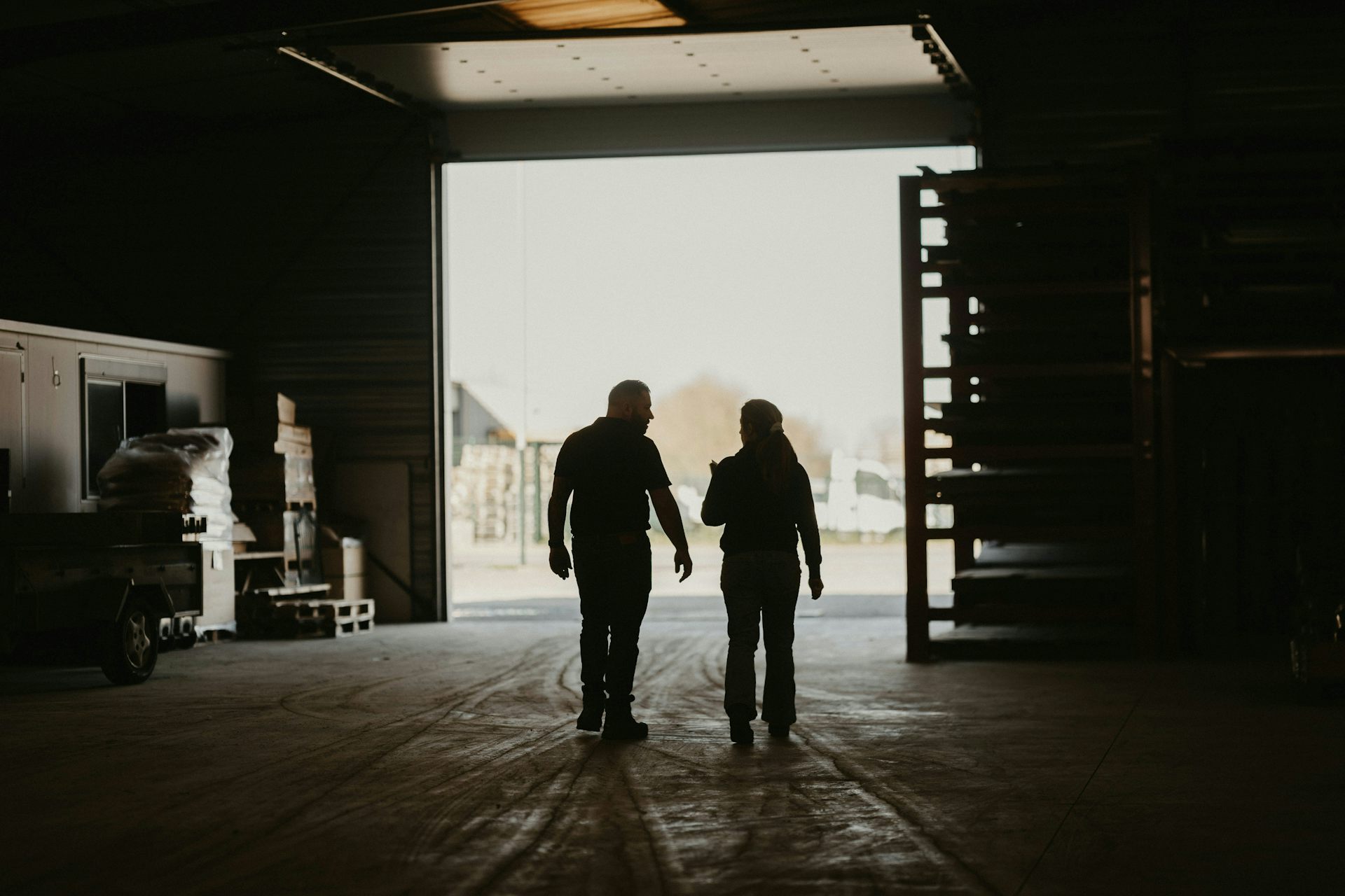 A man and a woman walk through a warehouse together