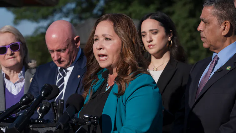 A woman speaks in front of a podium.