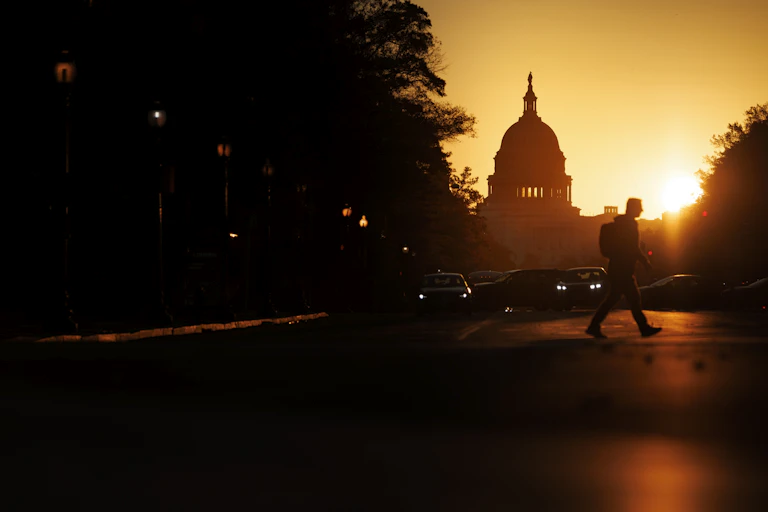 The sun begins to rise behind a federal building.