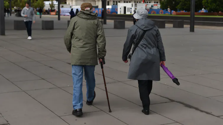 An elderly couple is seen walking