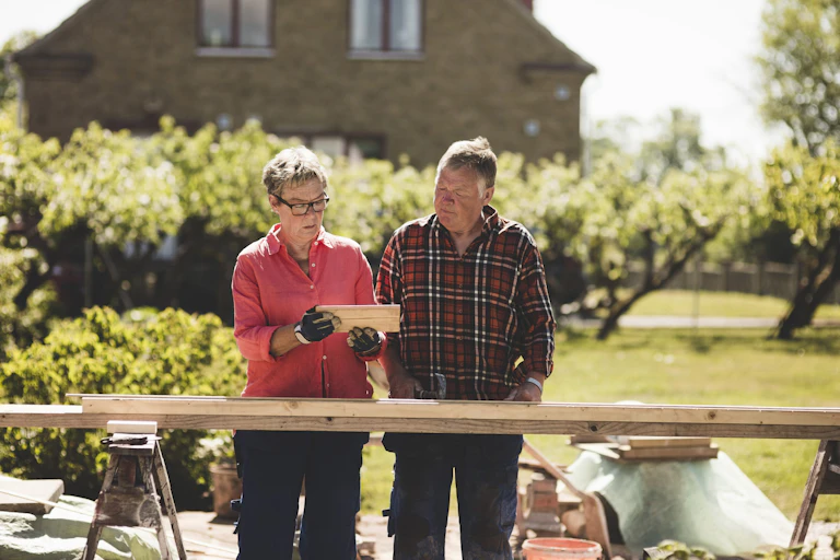 senior couple seen doing woodwork for a home renovation