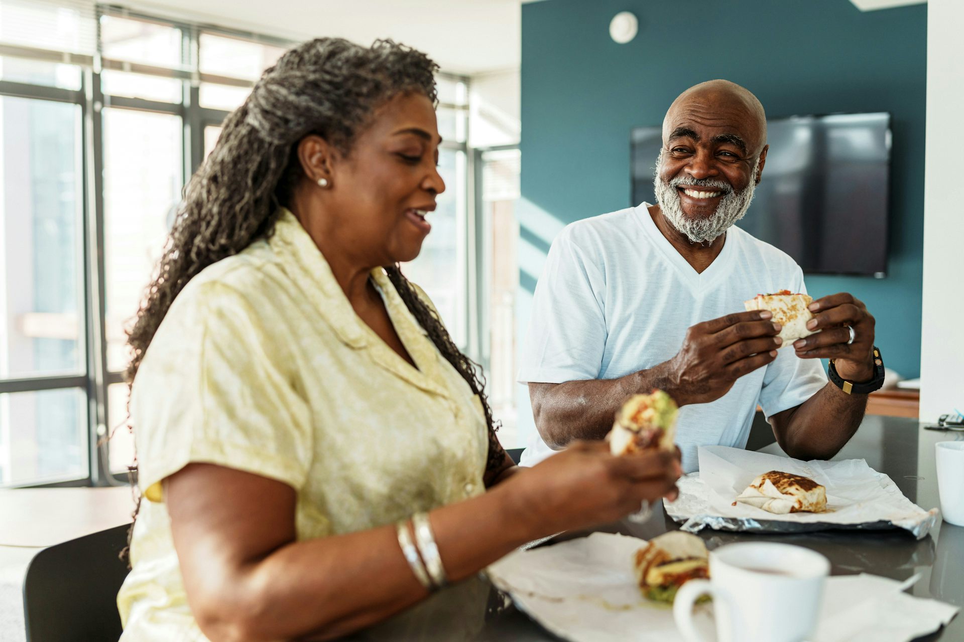 A man with a grey beard and a woman with greying hair at a table