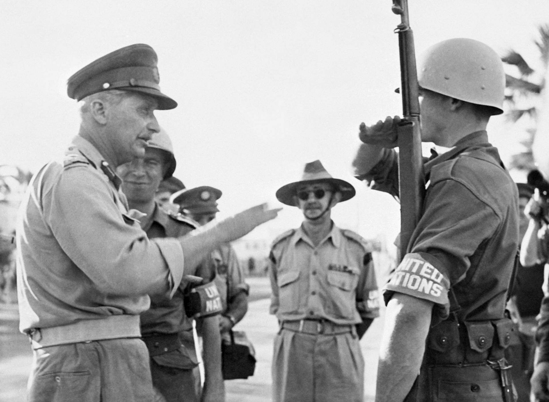 Two soldiers stand talking in a dated photo.