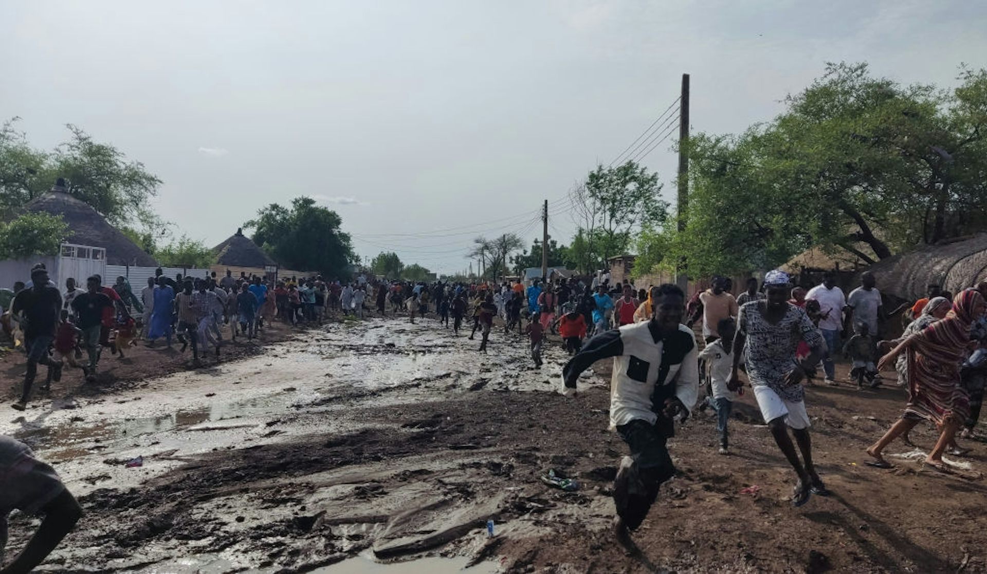 A group of people running on muddy ground