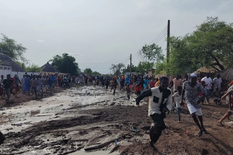A group of people running on muddy ground